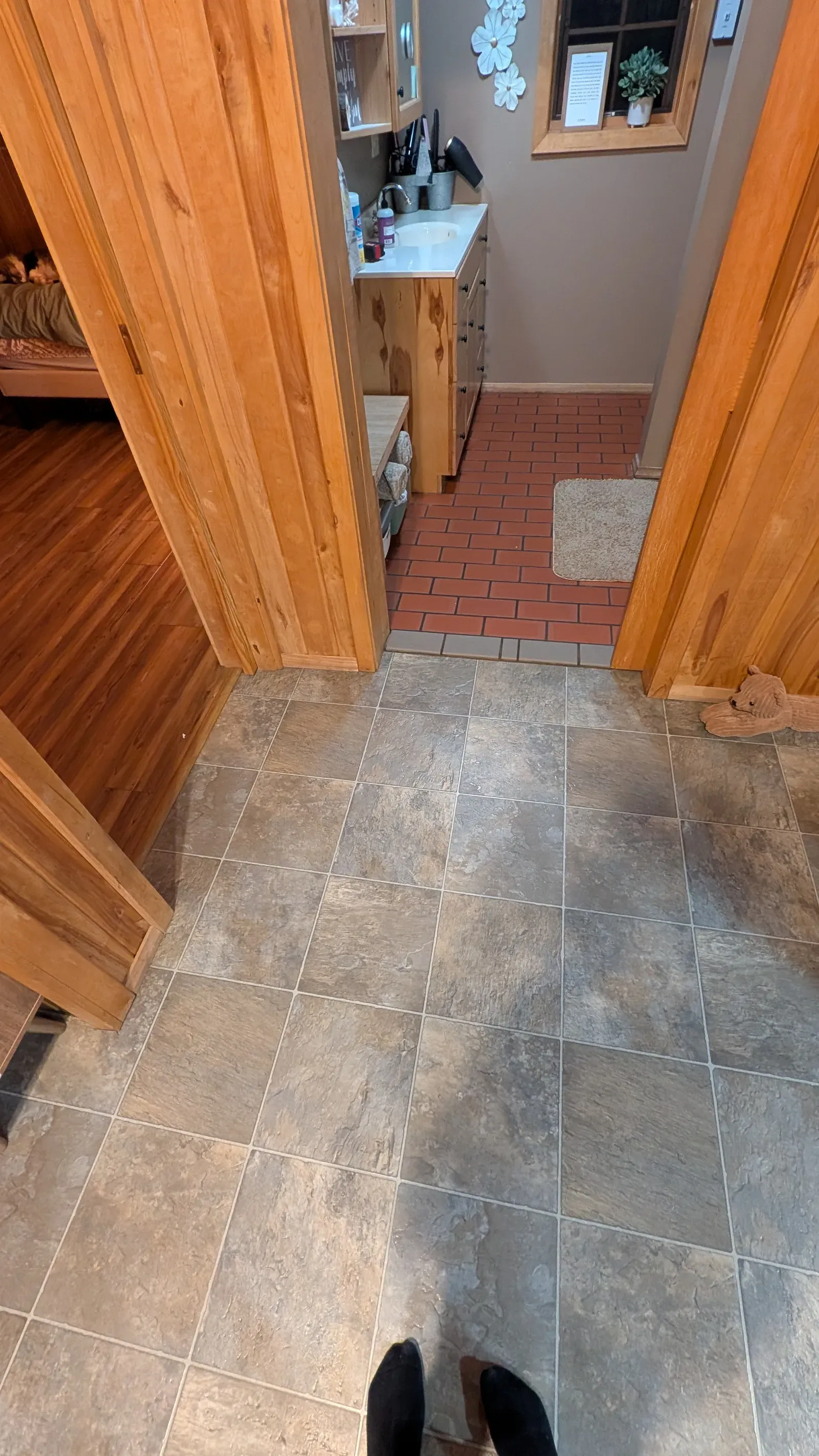 Hallway transition showing old floor tile leading into dated bathroom
