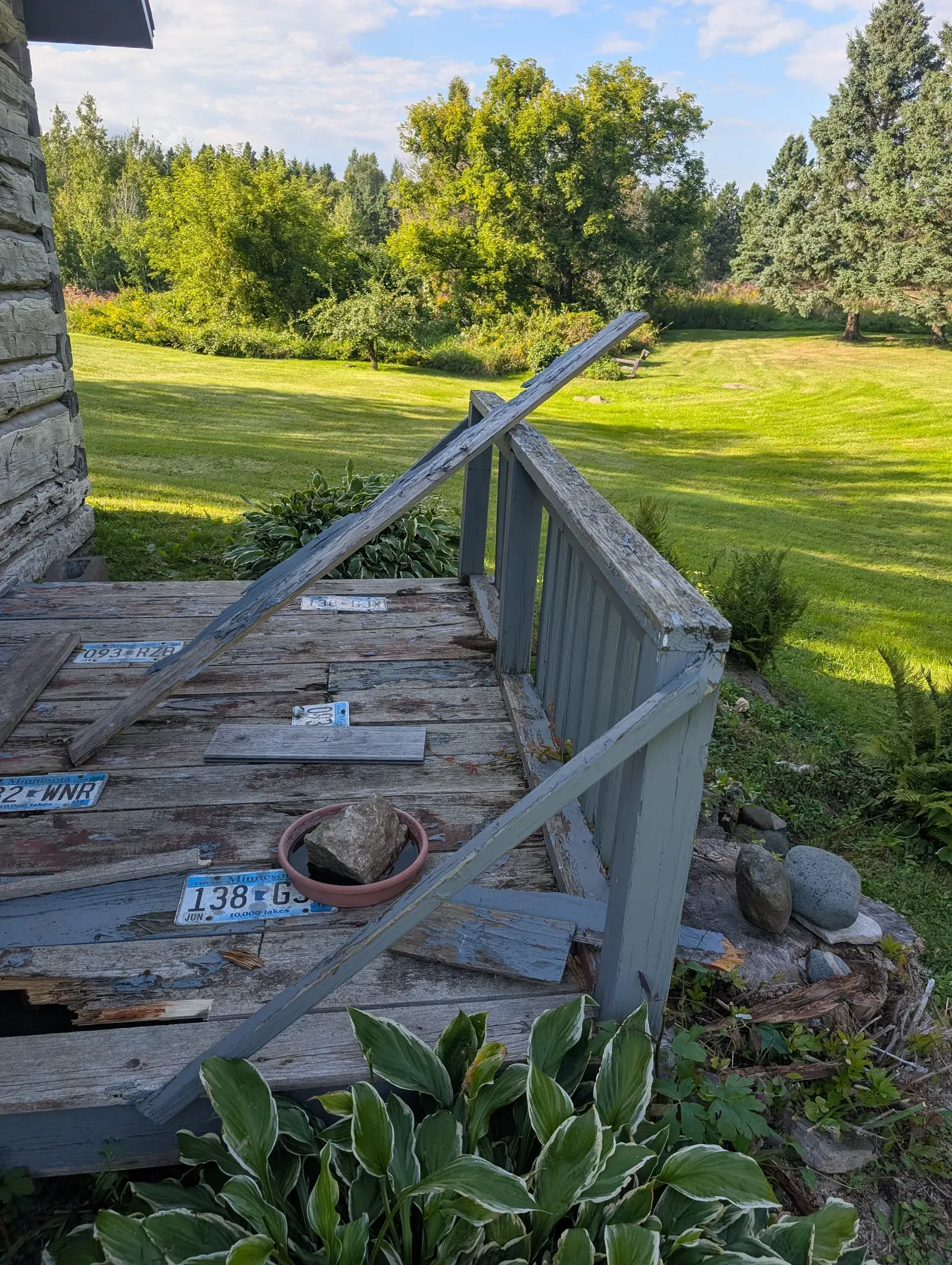 Deteriorated original deck in Hermantown, MN with rotted boards and collapsed railing