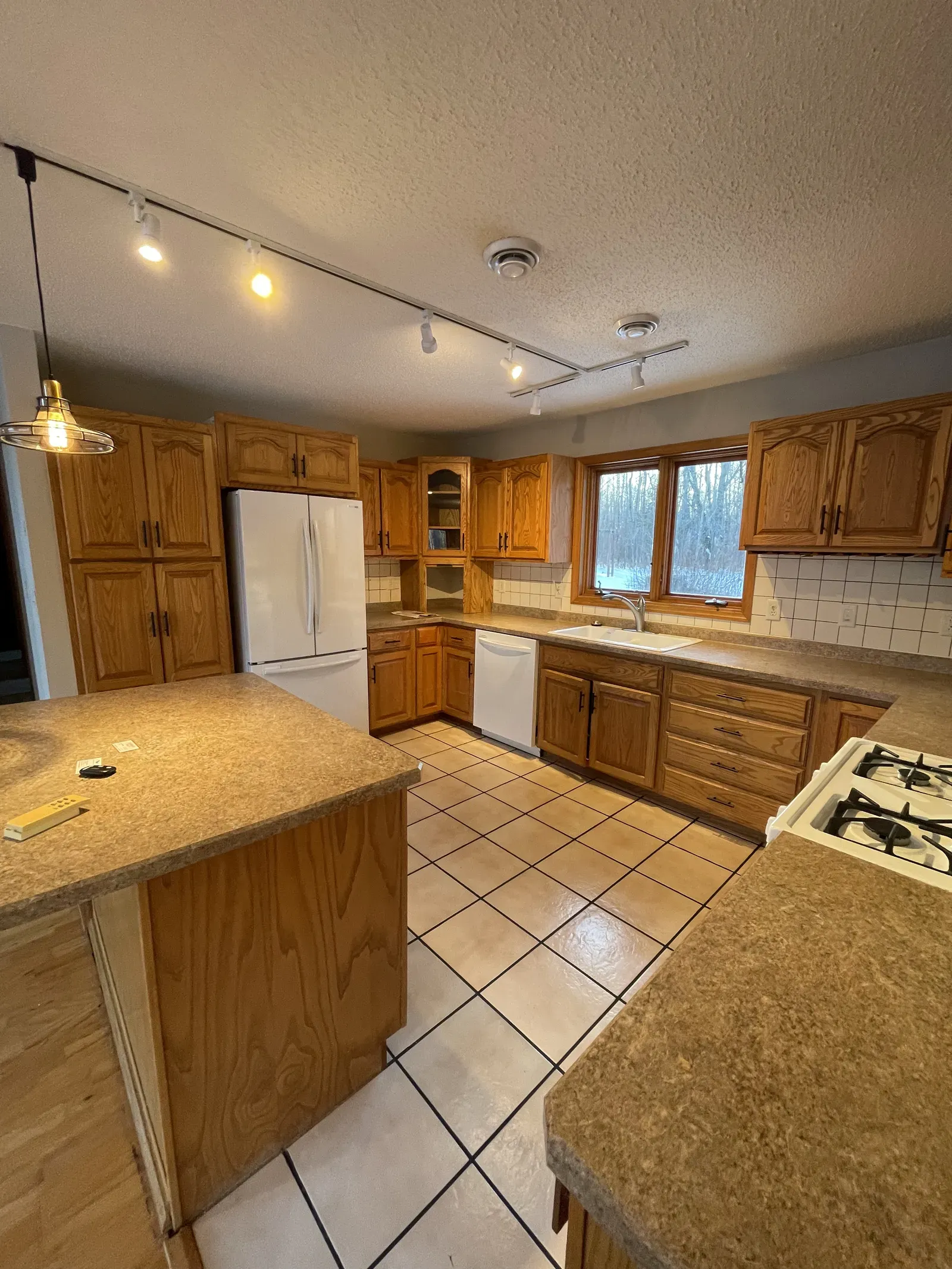 Original kitchen showing island, track lighting, and old countertops