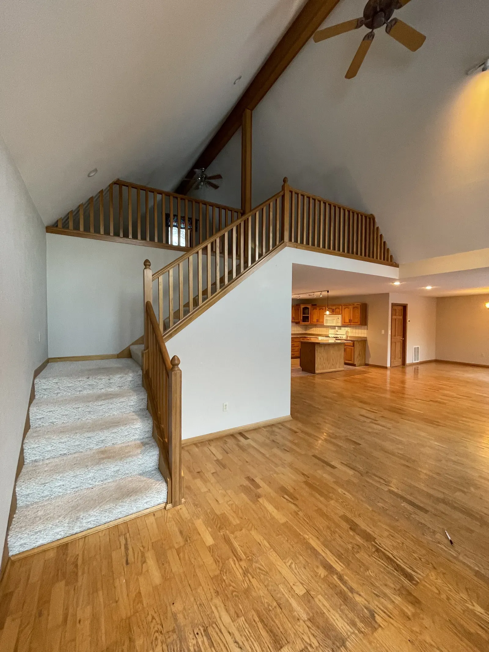 Original loft with oak railing, carpet stairs, and dated ceiling in Duluth home
