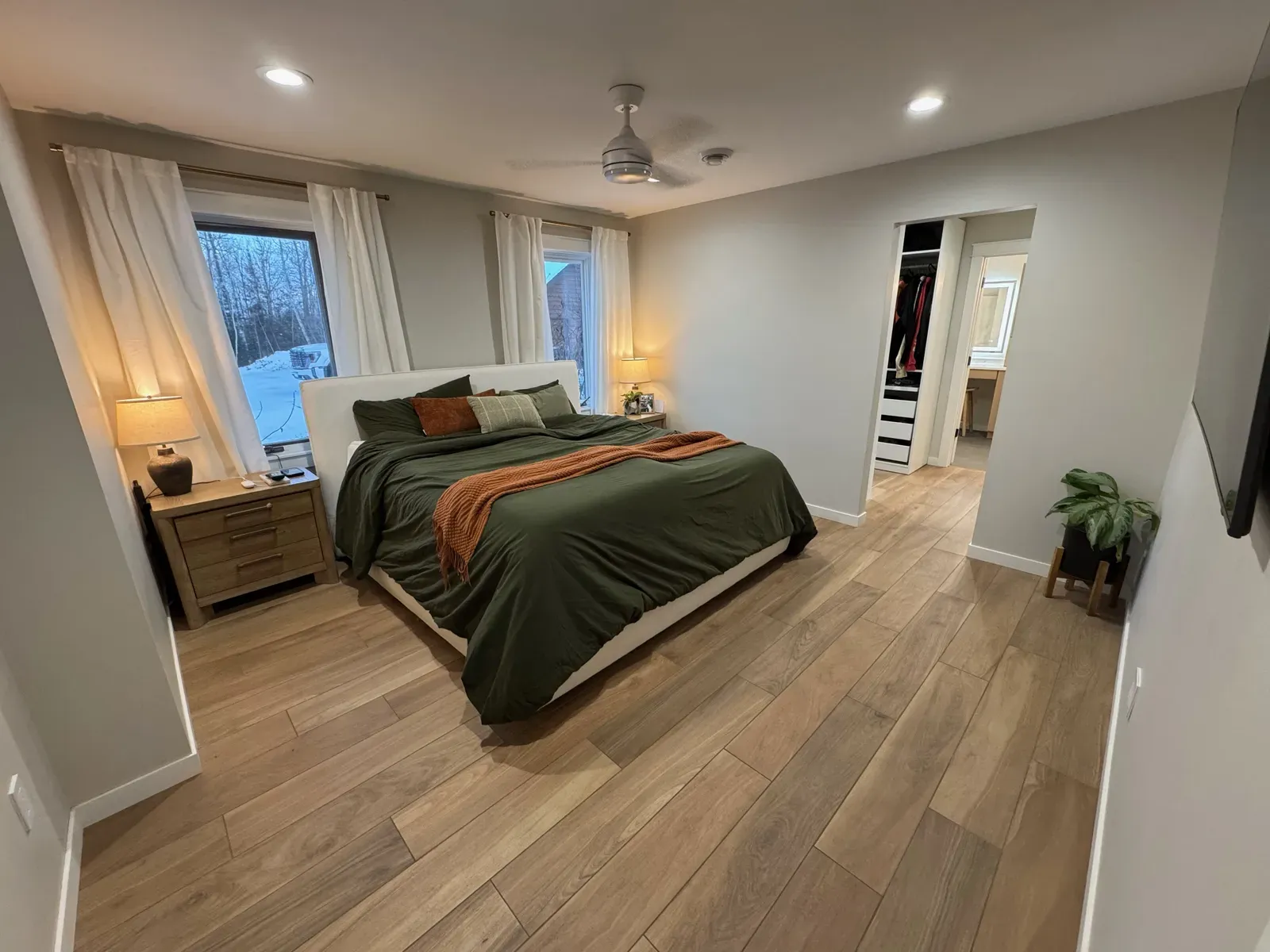 Renovated master bedroom with LVP flooring, recessed lighting, and modern finishes