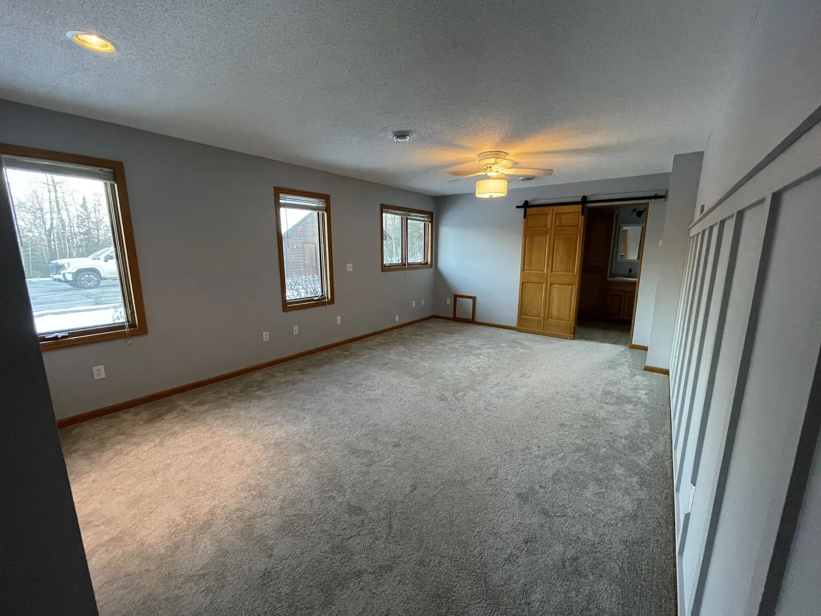 Master bedroom before renovation with carpet and barn door